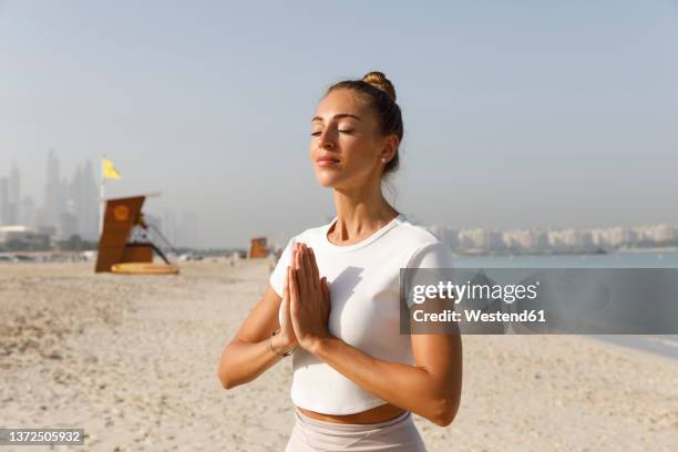 woman in a meditation pose on the beach - gesturing stock pictures, royalty-free photos & images