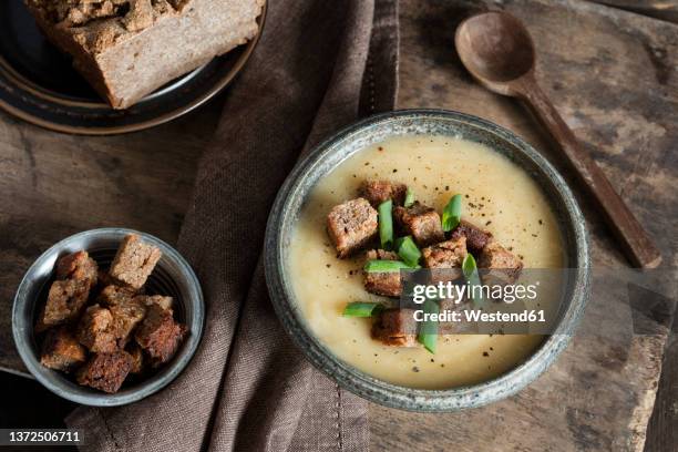 homemade jerusalem artichoke soup garnished with croutons and scallions in bowl - jerusalem artichoke stock pictures, royalty-free photos & images