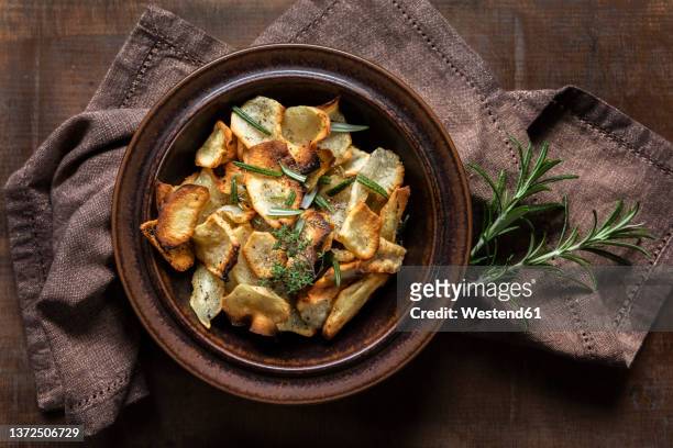 crispy jerusalem artichoke chips garnished with rosemary on table - artichoke stock pictures, royalty-free photos & images