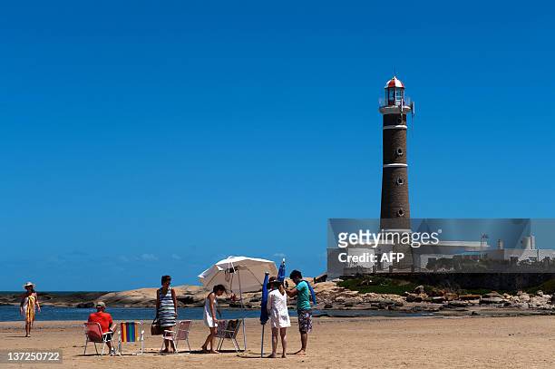 Tourists enjoy the beach near the lighthouse of Jose Ignacio, next to Punta del Este, one of the most exclusive seaside resorts of Latin America, 140...