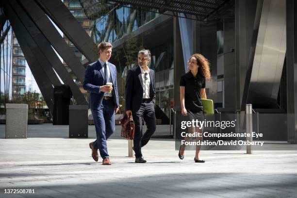 coworkers walking and talking in the city - cup day three stock pictures, royalty-free photos & images