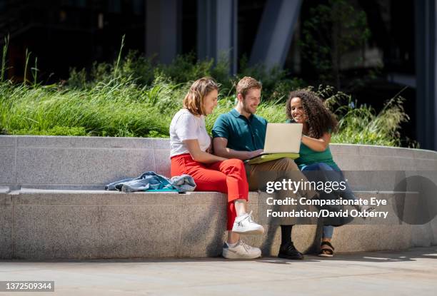 coworkers discussing project outside - gambe accavallate foto e immagini stock