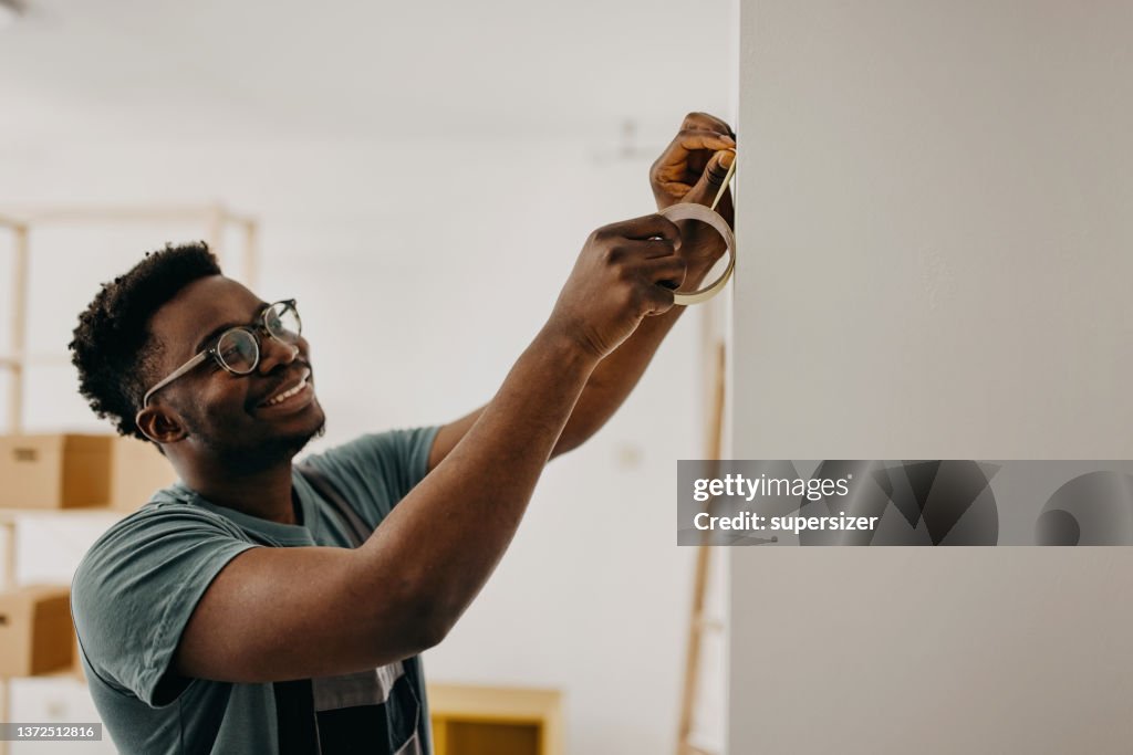 Pittore professionista afroamericano dipinge il muro all'interno