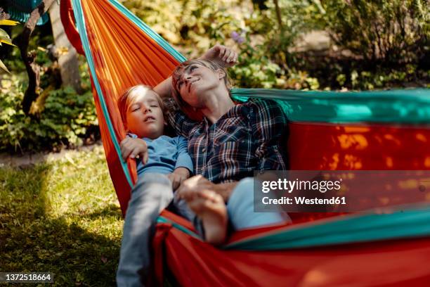 mother day dreaming by son sleeping in hammock - kid day dreaming photos et images de collection