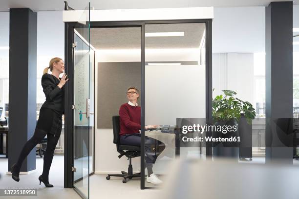 smiling businessman talking with colleague in modern office - office cabin ストックフォトと画像