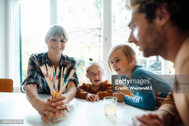 family playing mikado at home - mikado stock pictures, royalty-free photos & images