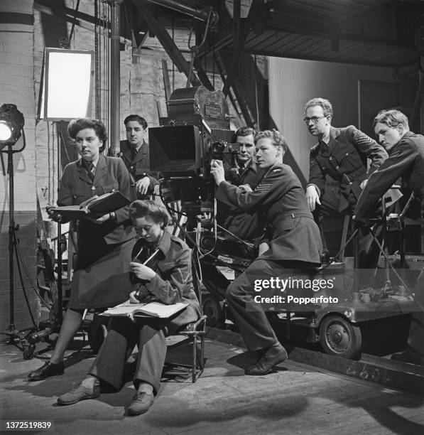 Cinematographer Harry Waxman stands 2nd from right with other film crew members from the Royal Air Force Film Production Unit to shoot a scene from...