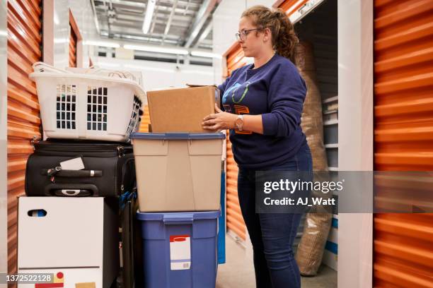 woman moving boxes at self storage unit - possession stock pictures, royalty-free photos & images