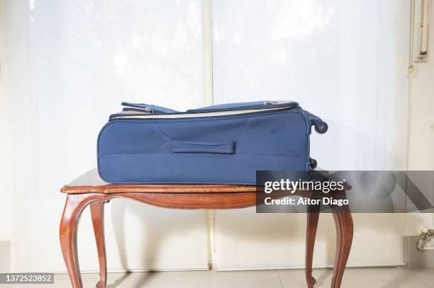 suitcase on a small table ready to travel. - suitcase close foto e immagini stock