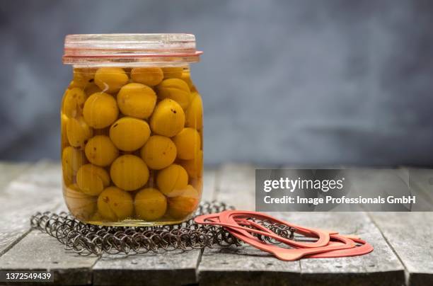 preserved small yellow plums in a glass jar - mirabellen stockfoto's en -beelden