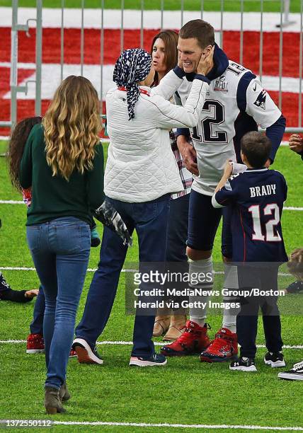 New England Patriots quarterback Tom Brady holds his daughter Vivian Lake Brady as his wife Gisele Bundchen scrambles to get a picture at NRG Stadium...