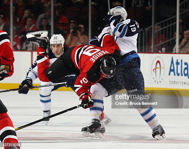 Jim Slater of the Winnipeg Jets flips Zach Parise of the New Jersey Devils during the first period at the Prudential Center on January 17, 2012 in...