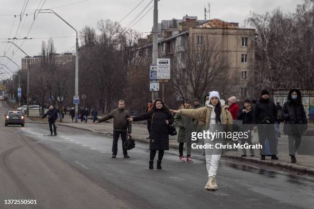 People hitchhike and wait for buses as people try to leave the city on February 24, 2022 in Kyiv, Ukraine. Overnight, Russia began a large-scale...