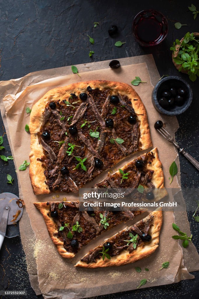 Pissaladiere pizza with onions, anchovies and greek basil