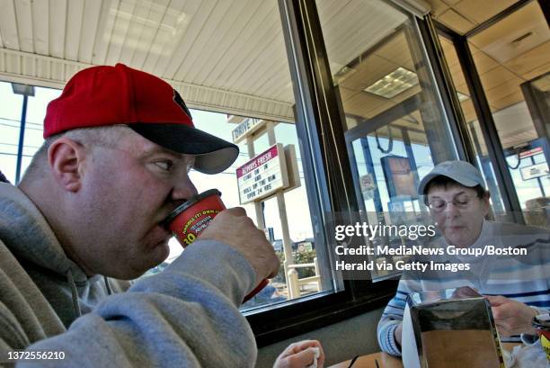 Eric Myers of Tiverton RI , left, sips a cup of coffee while dining at Tim Horton's on Newton St in Fall River Thursday with his mother Carol Myers ,...