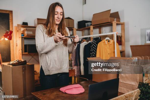 a woman is photographing a pink hat to post a new item on her online shop - secondhand försäljning bildbanksfoton och bilder