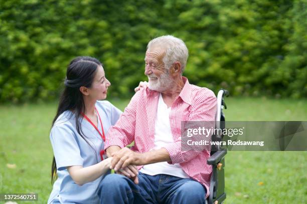 nurse caregiving help older male wheelchair-bound discussing enjoyable at backyard - elderly cognitive stimulation therapy stockfoto's en -beelden