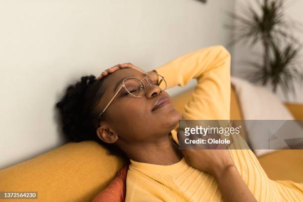 porträt einer schönen afrikanischen frau, die ein nickerchen macht - woman taking a nap stock-fotos und bilder