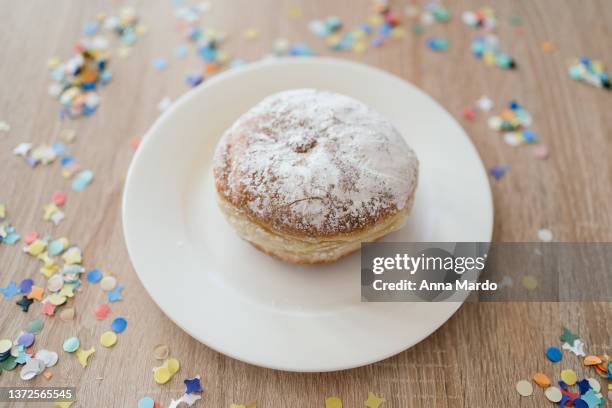 a german traditional carnival sweet called krapfen with powdered sugar on a white plate - azúcar en polvo fotografías e imágenes de stock