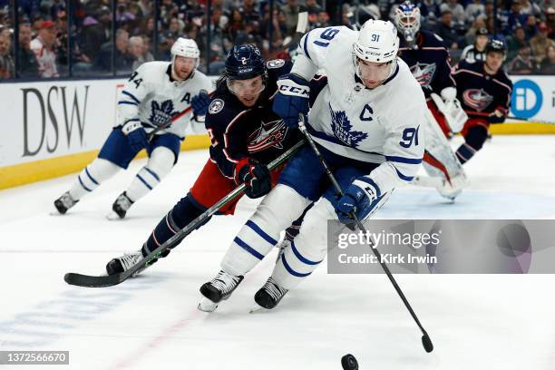 John Tavares of the Toronto Maple Leafs and Andrew Peeke of the Columbus Blue Jackets battle for control of the puck during the game at Nationwide...