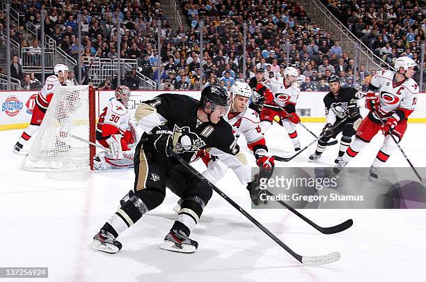 Evgeni Malkin of the Pittsburgh Penguins controls the puck in front of the defense of Tim Gleason of the Carolina Hurricanes on January 17, 2012 at...