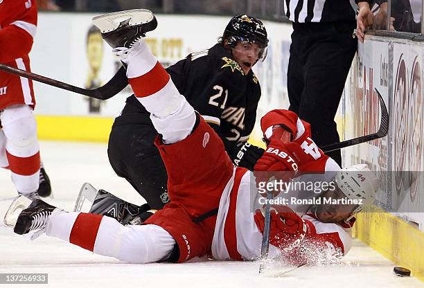 Todd Bertuzzi of the Detroit Red Wings falls while skating the puck against Loui Eriksson of the Dallas Stars at American Airlines Center on January...