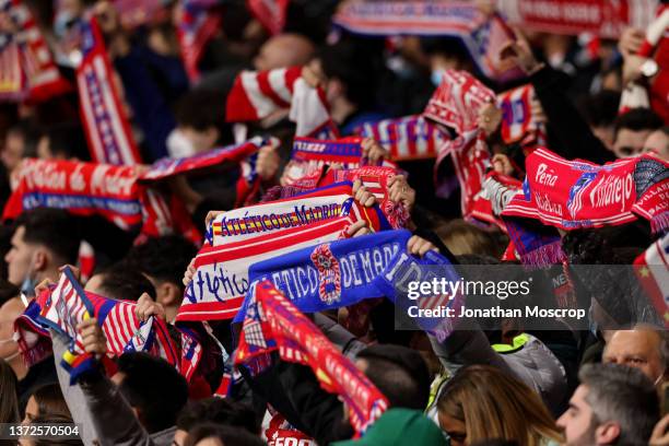 Atletico Madrid fans hold aloft club scarves during the UEFA Champions League Round Of Sixteen Leg One match between Atletico Madrid and Manchester...