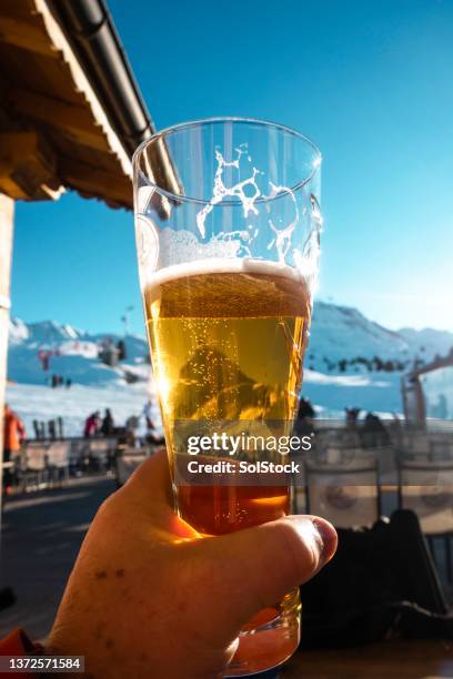 enjoying a beer in the alps - après ski stockfoto's en -beelden