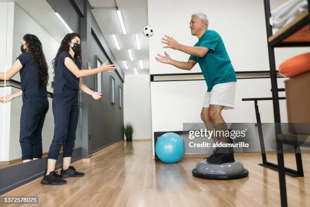 senior patient catching ball on therapy ball - catching ball stock pictures, royalty-free photos & images