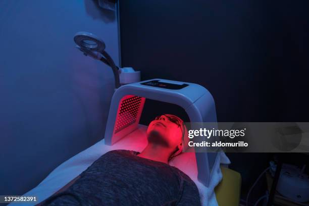 jeune femme faisant de la luminothérapie rouge sur le visage - luminothérapie photos et images de collection