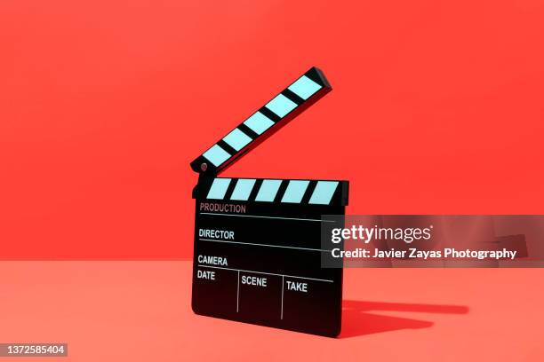 clapper board on red background - claqueta de cine fotografías e imágenes de stock