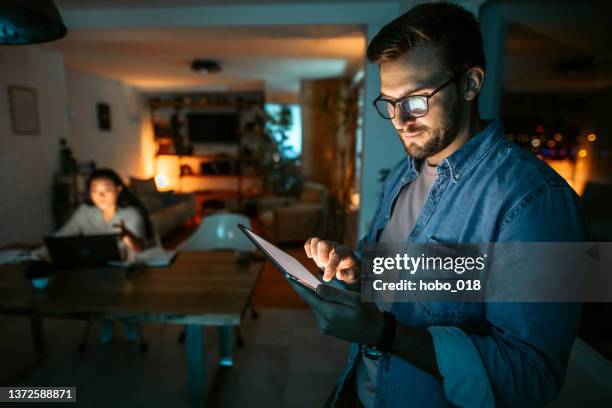 portrait of mid adult white businessman holding digital tablet - telecommuting couple stock pictures, royalty-free photos & images