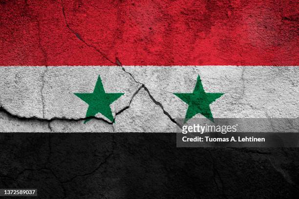 full frame photo of a weathered flag of syria painted on a cracked wall. - syrian flag stock-fotos und bilder