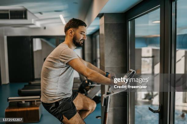 man on exercise bike - gym stock pictures, royalty-free photos & images