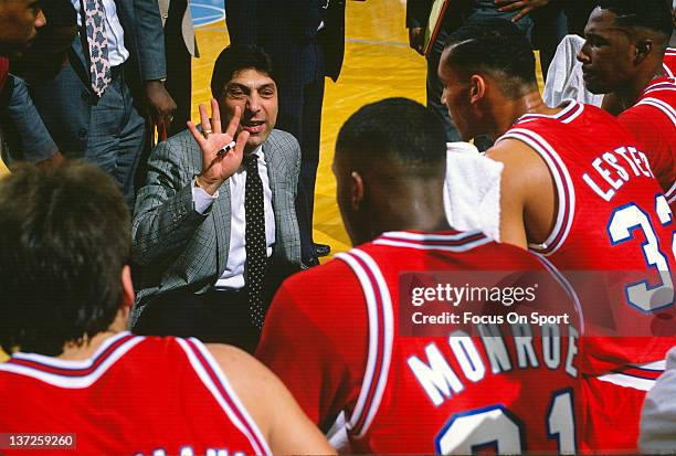 Head coach Jimmy Valvano of the North Carolina State Wolfpack talks with his team while there's a timeout against the North Carolina Tar Heels during...