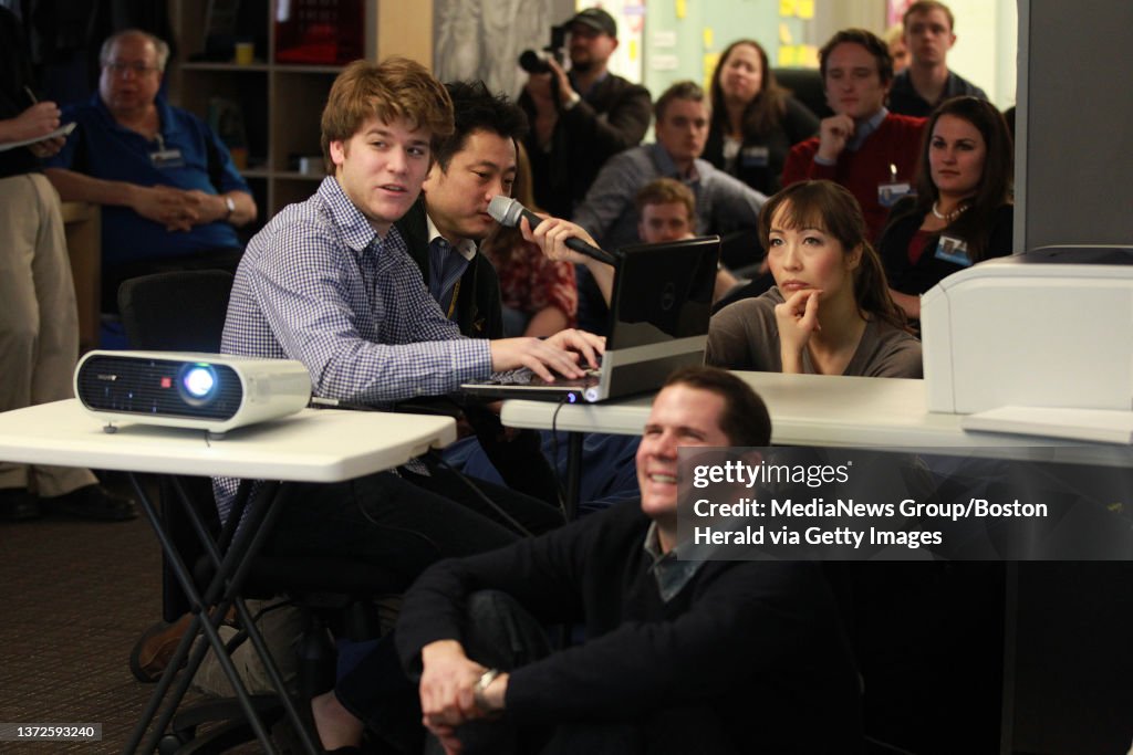Boston, MA — Codecademy co-founder and CEO Zach Sims (center) gives a demonstration at FreeCause, a Boston company which has begun an initiative to have all of its employees learn javascript by the end of the year. FreeCause CEO Mike Jaconisits o