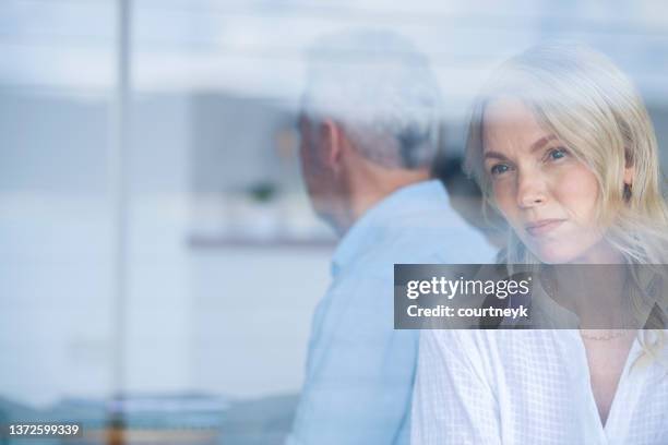 mature couple fighting at home sitting on the sofa - ignore stockfoto's en -beelden