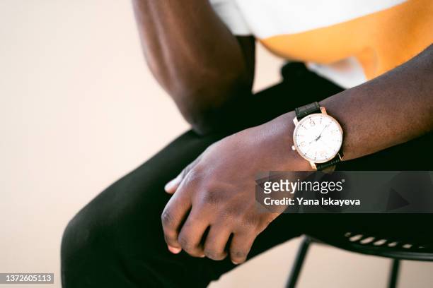 dark skin hand with classical watch on the wrist - luxury watch stock-fotos und bilder