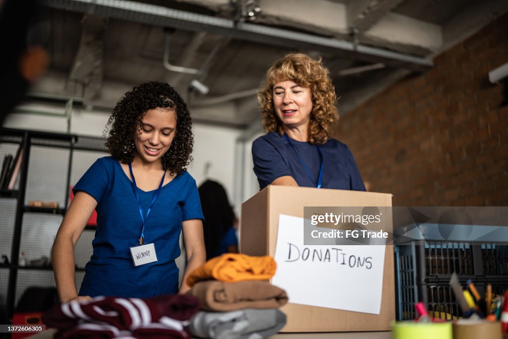 Volunteers arranging clothes donations in a community charity donation center