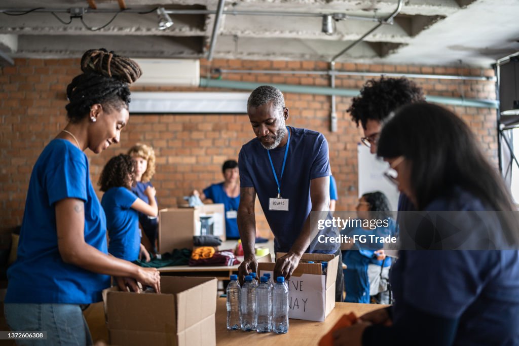 Volunteers arranging donations in a community charity donation center