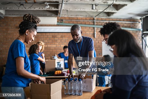 Volunteers arranging donations in a community charity donation center Volunteers arranging donations in a community charity donation center