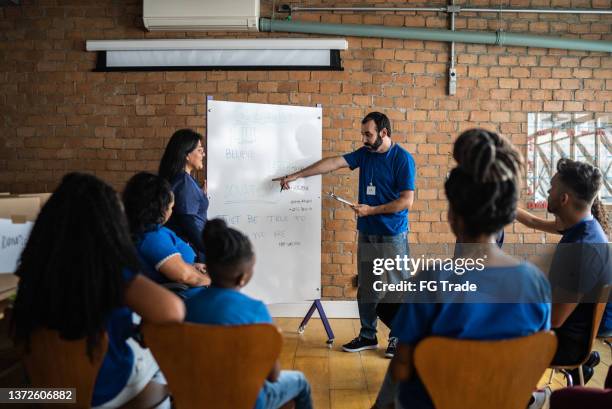 mid adult man talking in a meeting at a community center - community centre stock pictures, royalty-free photos & images