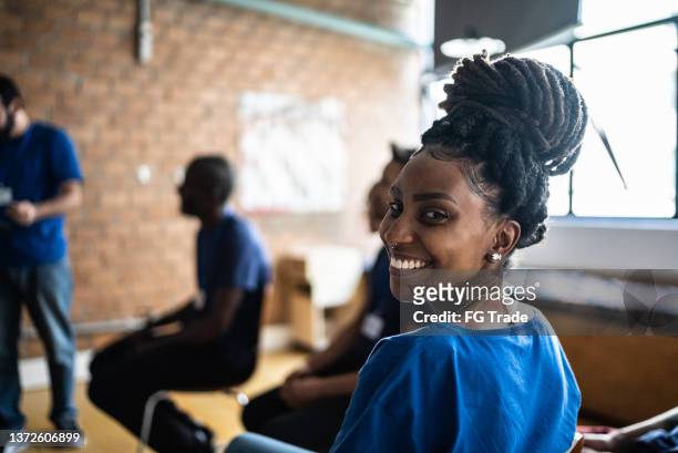 portrait of a young woman in a meeting at a community center - black community stock pictures, royalty-free photos & images