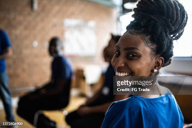 retrato de una joven en una reunión en un centro comunitario - ayuda humanitaria fotografías e imágenes de stock