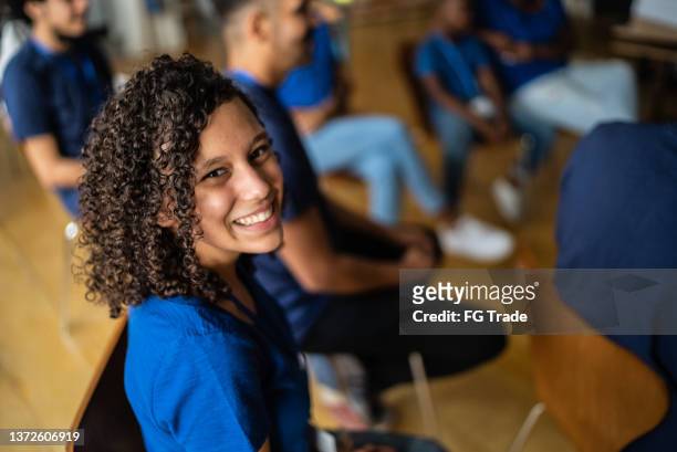porträt eines teenagers bei einem treffen in einem gemeindezentrum - großzügigkeit stock-fotos und bilder