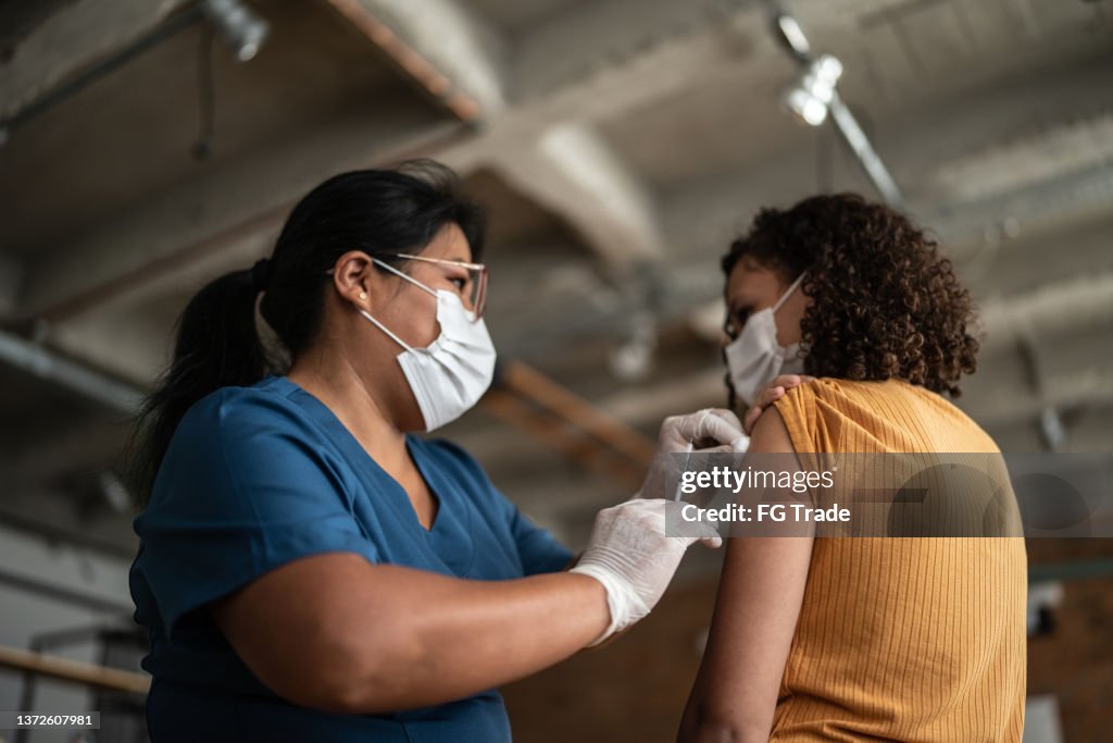 Teenage girl getting vaccinated in a medical clinic