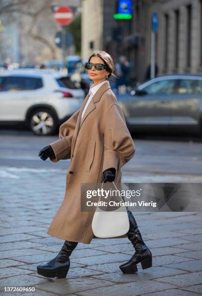 Victoria Barbara is seen wearing total look Prada: beige coat, white bag, black boots, sunglasses, white button shirt during the Milan Fashion Week...