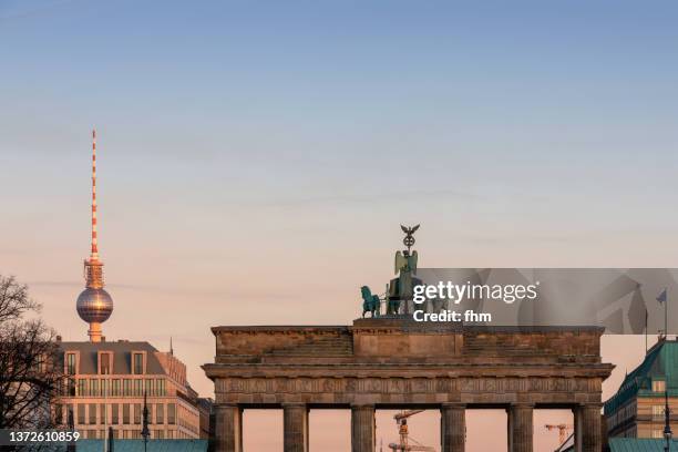 brandenburger tor (brandenburg gate) and tv-tower at sunset (berlin, germany) - fernsehturm berlijn stock pictures, royalty-free photos & images