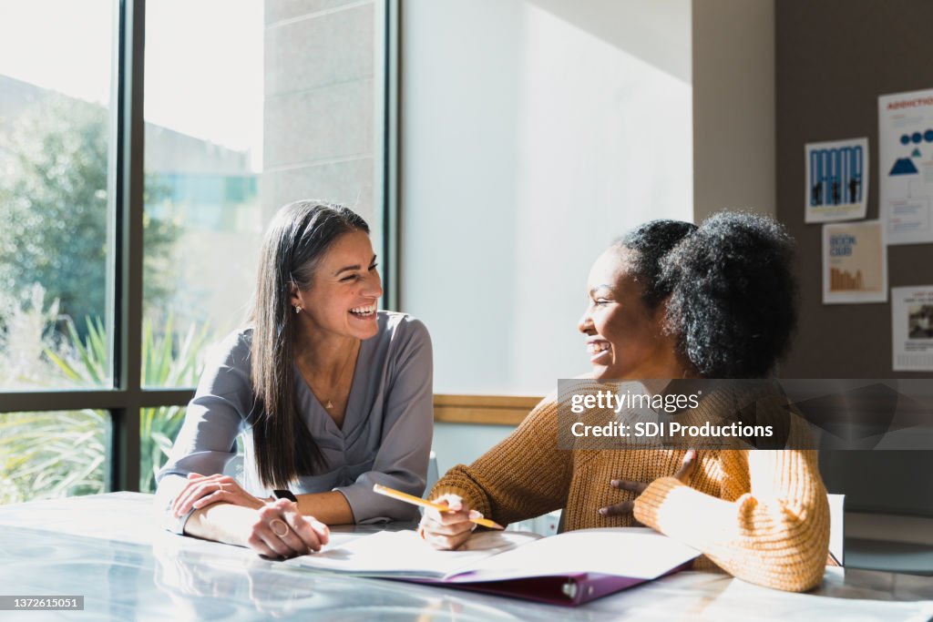 Caring female high school teacher tutors female student