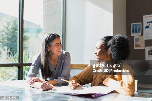 caring female high school teacher tutors female student - role model stock pictures, royalty-free photos & images